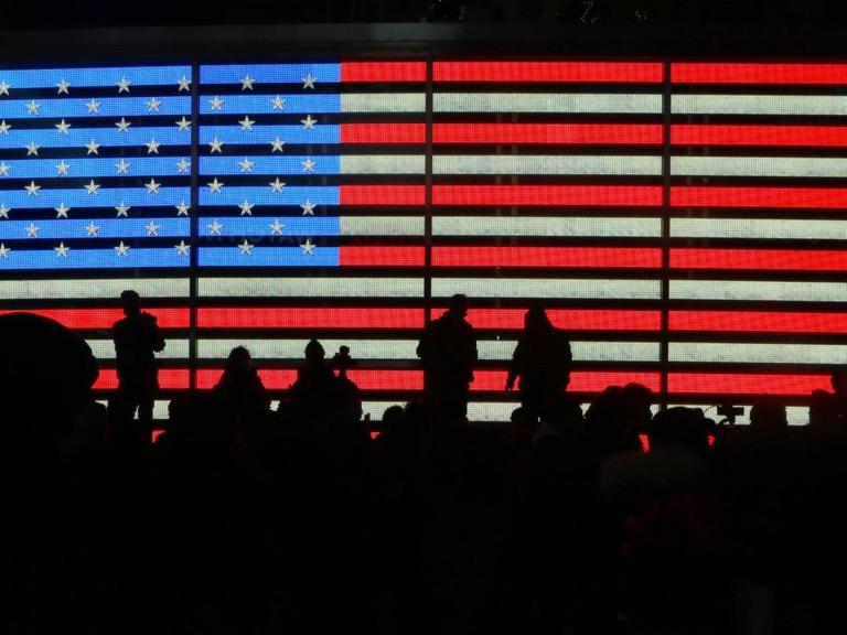 Am New Yorker Times Square leuchtet eine amerikanische Flagge in der Nacht.