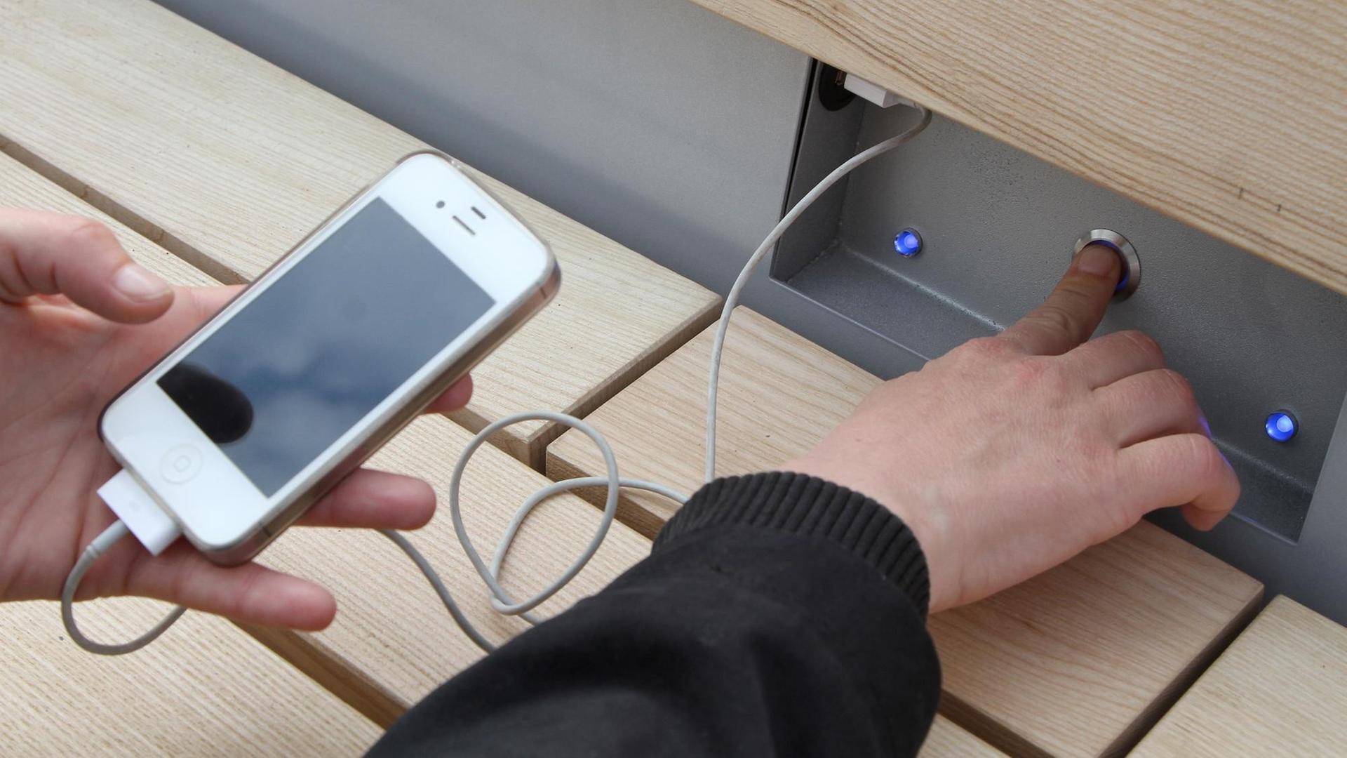 Ein Handy wird per USB-Kabel an den Strom angeschlossen Ein Handy wird per USB-Kabel an den Strom angeschlossen
