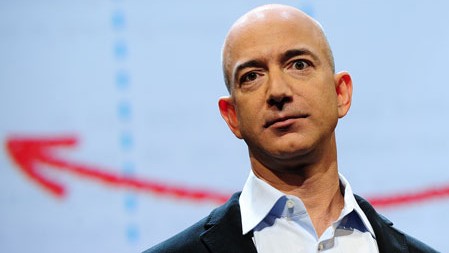 Portraitfoto: Amazon-Gründer und -Präsident Jeff Bezos steht vor einer Videowand auf der gezeichnete Pfeile zu sehen sind.