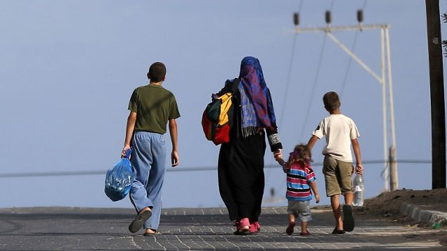 Vier Menschen, darunter zwei Kinder, gehen mit gepackten StraÃen auf einer StraÃe. Vier Menschen, darunter zwei Kinder, gehen mit gepackten StraÃen auf einer StraÃe.