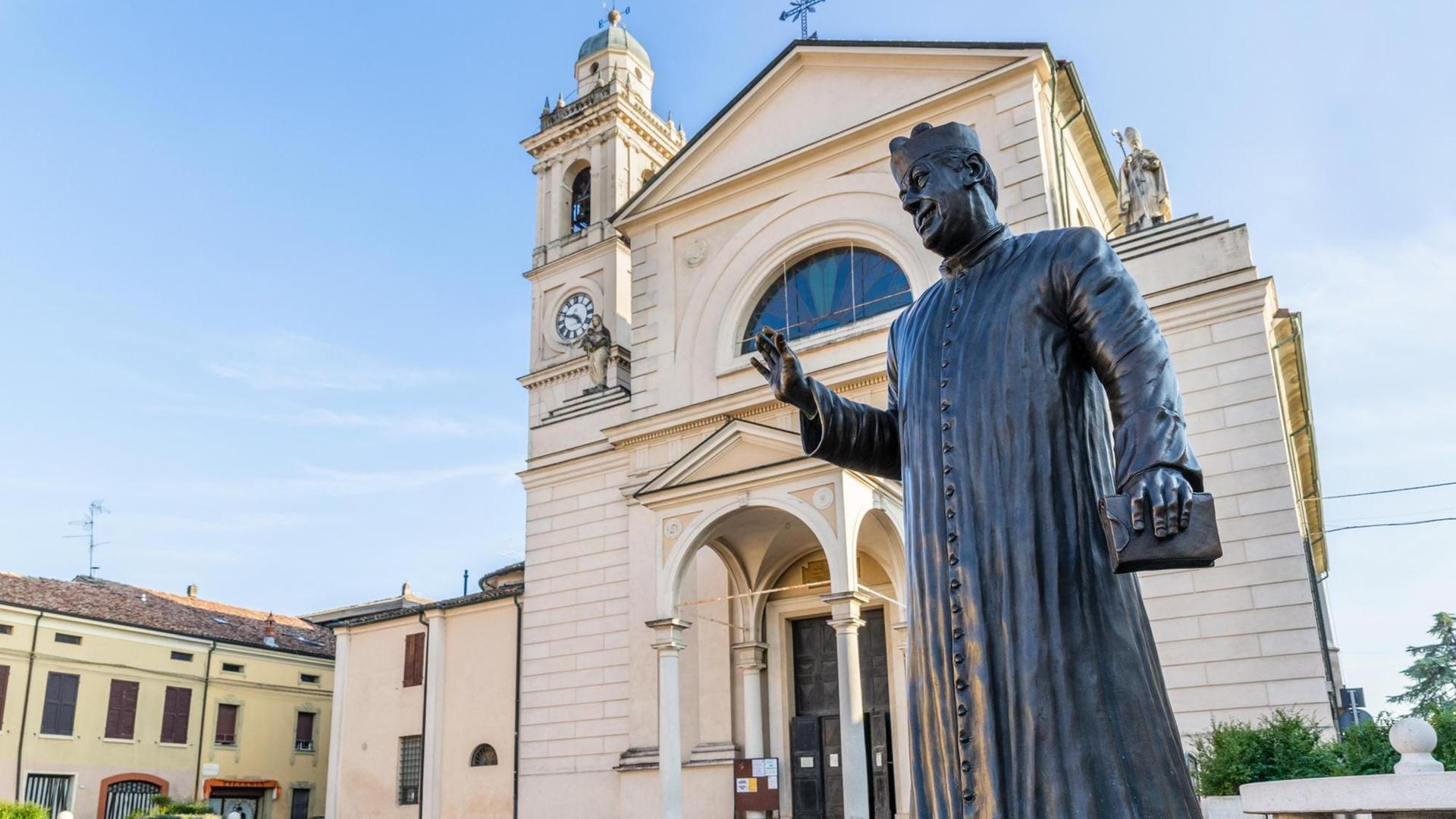 Statue von Don Camillo auf der Piazza Giacomo Matteotti vor der Kirche Santa Maria Nascente, Brescello, Provinz Reggio Emilia, Italien Statue von Don Camillo auf der Piazza Giacomo Matteotti vor der Kirche Santa Maria Nascente, Brescello, Provinz Reggio Emilia, Italien