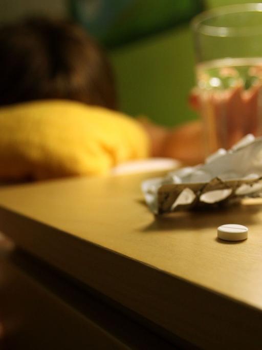 Tabletten liegen vor einem Bett