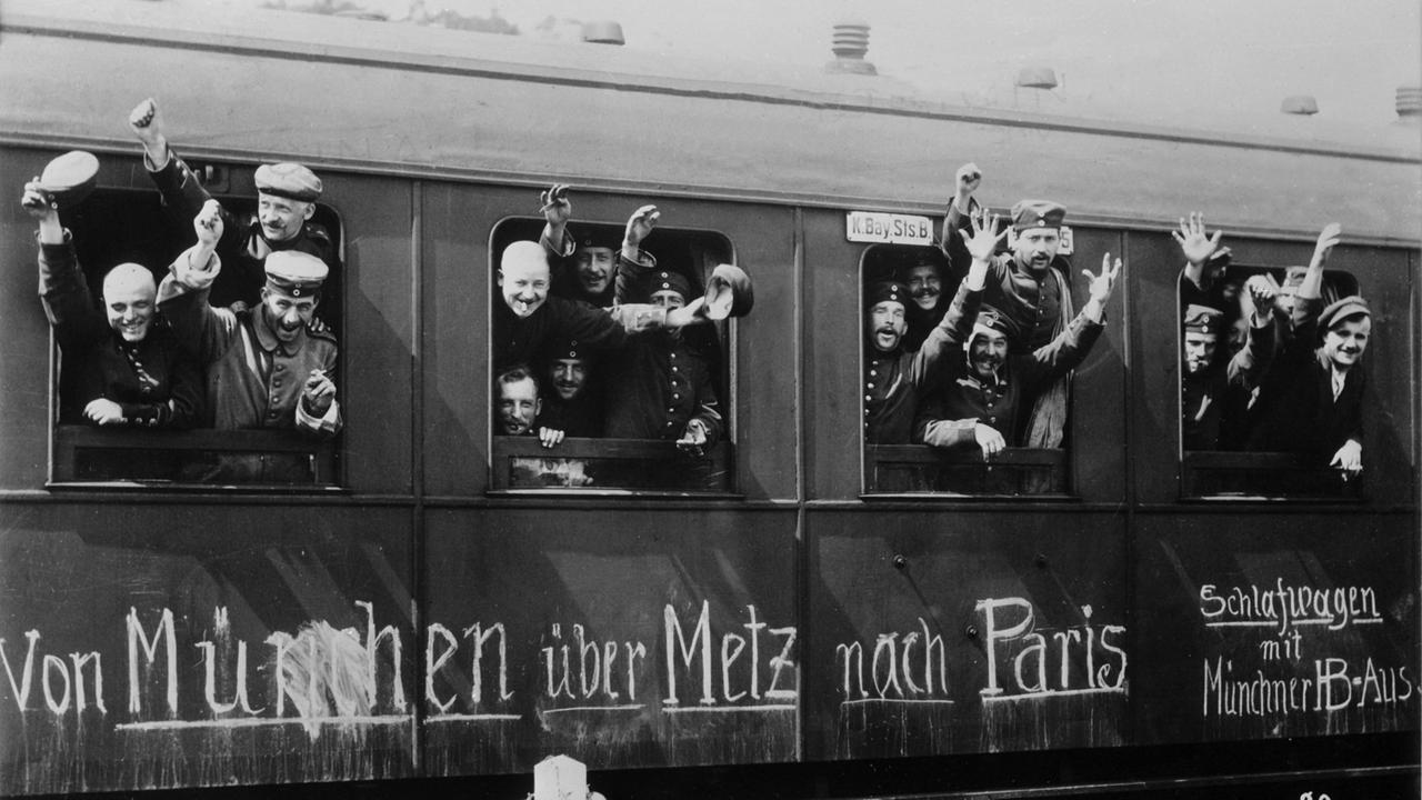Zu sehen sind jubelnde Soldaten am Fenster eines Zuges, der sie im August 1914 an die Front des Ersten Weltkrieges bringt. Zu sehen sind jubelnde Soldaten am Fenster eines Zuges, der sie im August 1914 an die Front des Ersten Weltkrieges bringt.