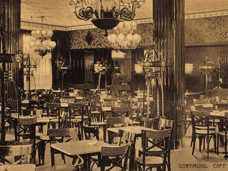 Blick in das ehemalige Café Central in Dortmund (um 1917). Es sind Tische, Kronleuchter und Säulen zu sehen.