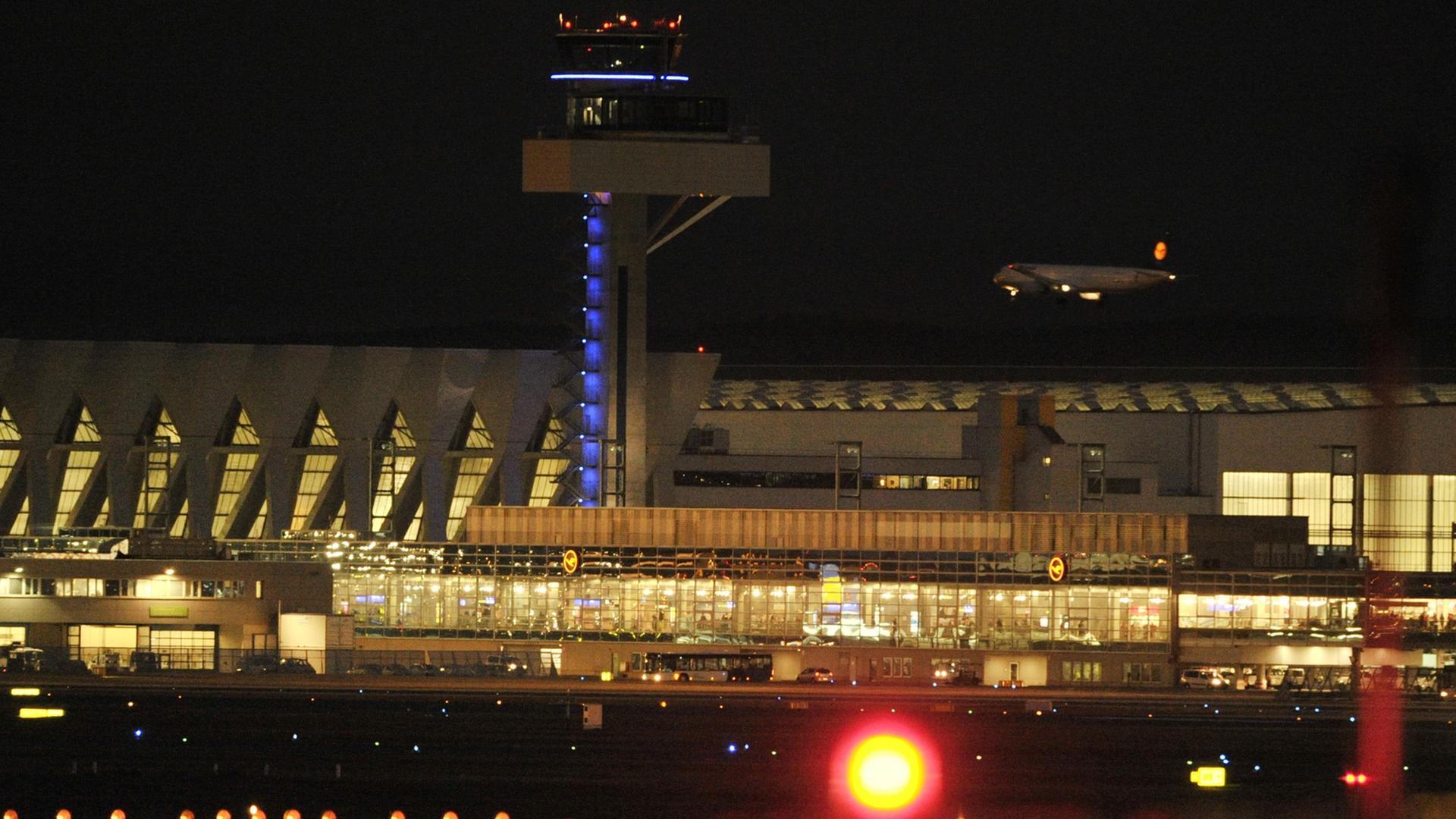 Hinter den Wartungshallen der Lufthansa und dem neuen Tower setzt eine Passagiermaschine am Dienstag auf dem Flughafen von Frankfurt am Main auf der Nordwestbahn zur Landung an. Hinter den Wartungshallen der Lufthansa und dem neuen Tower setzt eine Passagiermaschine am Dienstag auf dem Flughafen von Frankfurt am Main auf der Nordwestbahn zur Landung an.