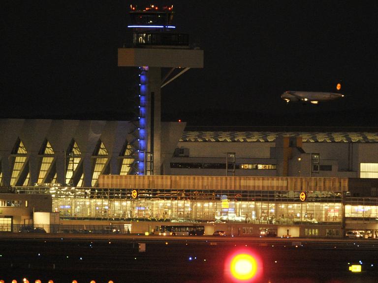 Hinter den Wartungshallen der Lufthansa und dem neuen Tower setzt eine Passagiermaschine am Dienstag auf dem Flughafen von Frankfurt am Main auf der Nordwestbahn zur Landung an.