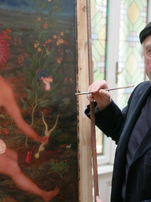 Der Maler Arik Brauer steht vor einem seiner bunten Bilder in seinem Atelier.