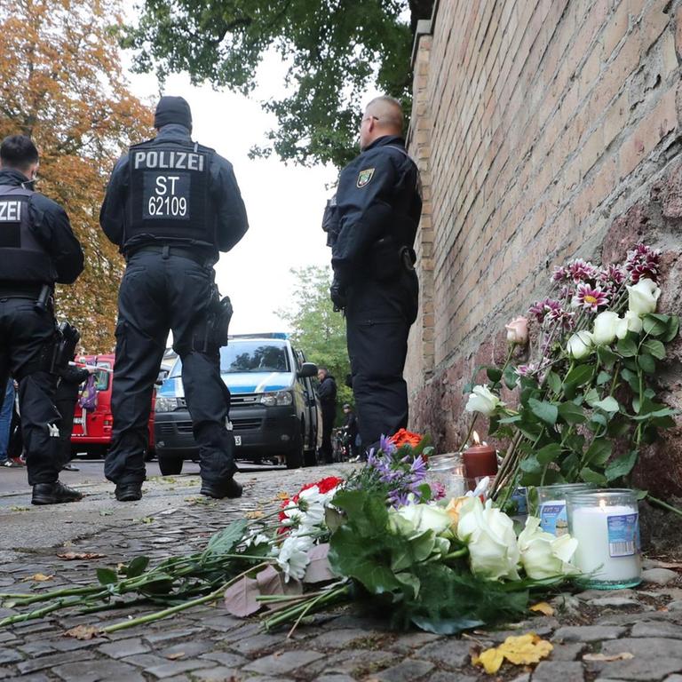 Nach Angriff in Halle (Saale) legen Menschen Blumen und Kerzen an der Tür der Synagoge nieder
