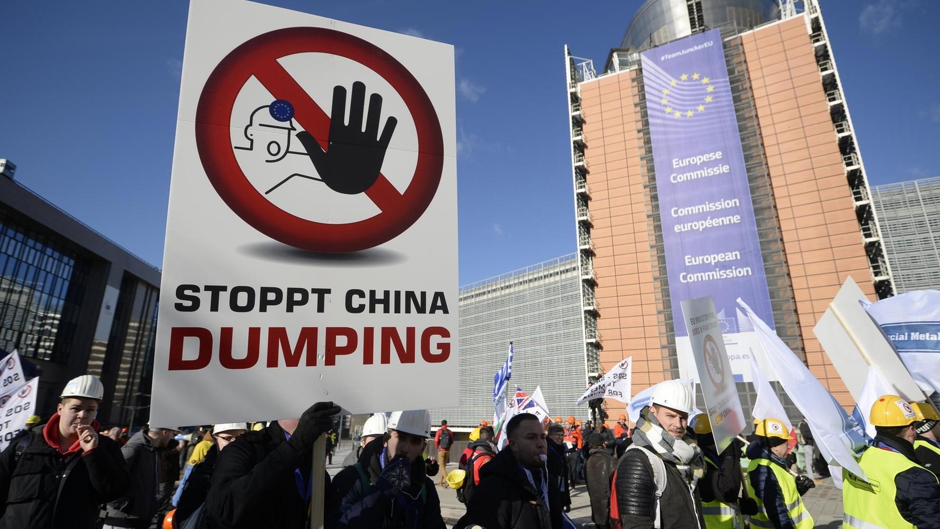 Mitglieder mehrerer Industrie-Gewerkschaften, besonders der Stahlindustrie, halten am 15.02.2016 in Brüssel ein Plakat mit dem Text "Stoppt China Dumping" hoch, um gegen die Dumpingpreise chinesischer Produkte im europäischen Markt zu protestieren. Mitglieder mehrerer Industrie-Gewerkschaften, besonders der Stahlindustrie, halten am 15.02.2016 in Brüssel ein Plakat mit dem Text "Stoppt China Dumping" hoch, um gegen die Dumpingpreise chinesischer Produkte im europäischen Markt zu protestieren.