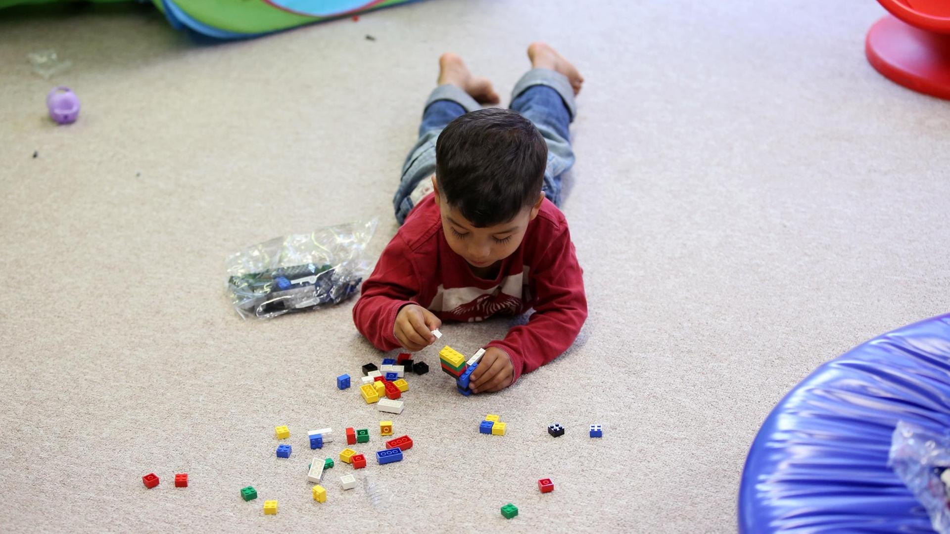 Ein Flüchtlingsjunge spielt im Kindergarten in der Zentralen Erstaufnahme (ZEA) Neuland in Hamburg Harburg mit gespendeten Spielsachen. Ein Flüchtlingsjunge spielt im Kindergarten in der Zentralen Erstaufnahme (ZEA) Neuland in Hamburg Harburg mit gespendeten Spielsachen.