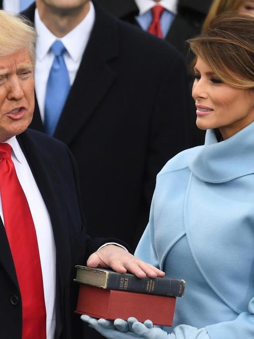 Donald Trump legt den Amtseid als 45. US-Präsident ab. Seine Hand liegt auf der Bibel. Neben ihm steht seine Frau Melania.