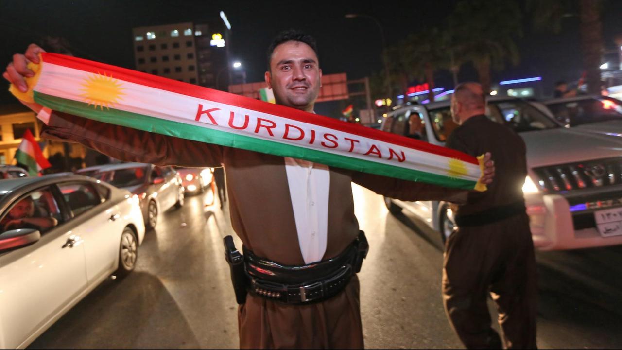 Ein Kurde im Nordirak hält nach dem Referendum ein Tuch mit dem Wort "Kurdistan" hoch. Ein Kurde im Nordirak hält nach dem Referendum ein Tuch mit dem Wort "Kurdistan" hoch.
