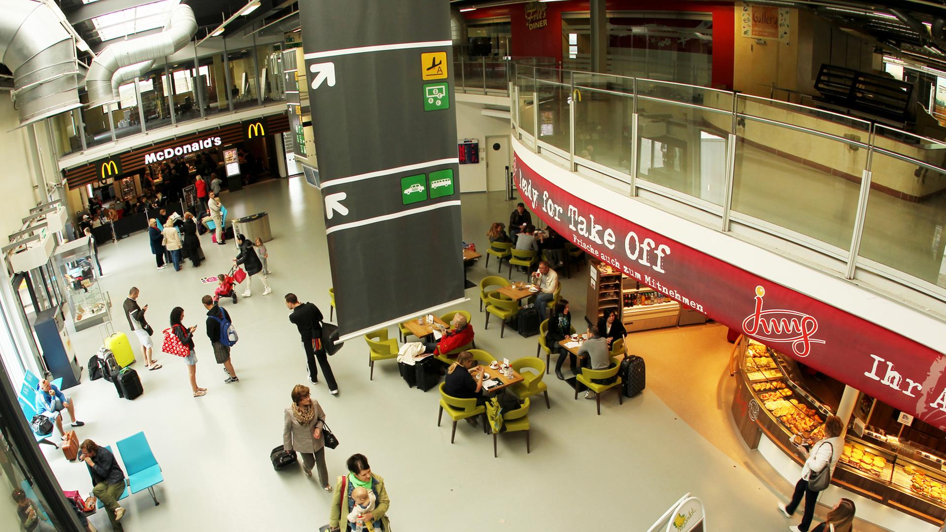 Passagiere laufen durch das Passagierterminal des Flughafens Frankfurt/Hahn in Lautzenhausen (Rheinland-Pfalz). Passagiere laufen durch das Passagierterminal des Flughafens Frankfurt/Hahn in Lautzenhausen (Rheinland-Pfalz).