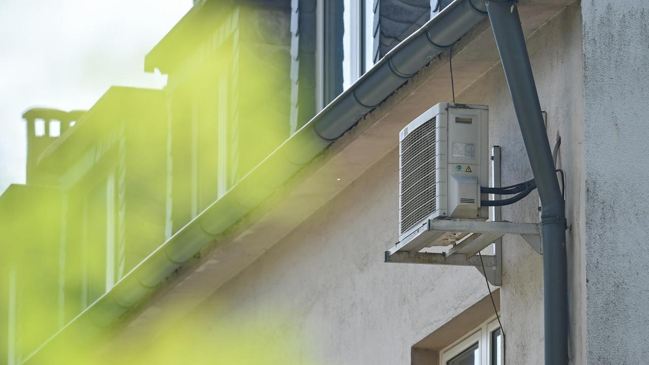 Das Außenteil einer Klimaanlage hängt in Essen (Nordrhein-Westfalen) an der Hauswand eines Mehrfamilienhauses.