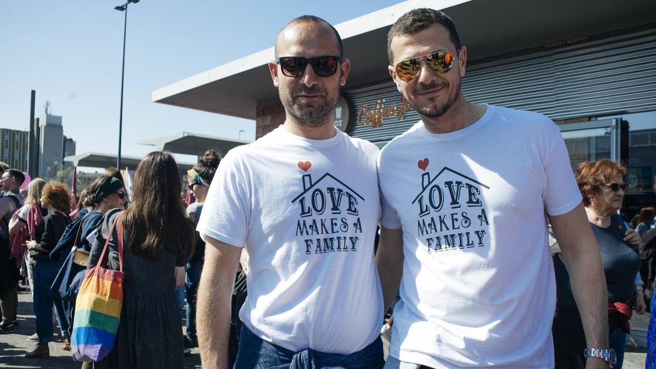 Zwei Männer im Rahmen der Gegenveranstaltung zum World Congress of Families in Verona 2019, auf deren T-Shirts 'Love makes a family' steht