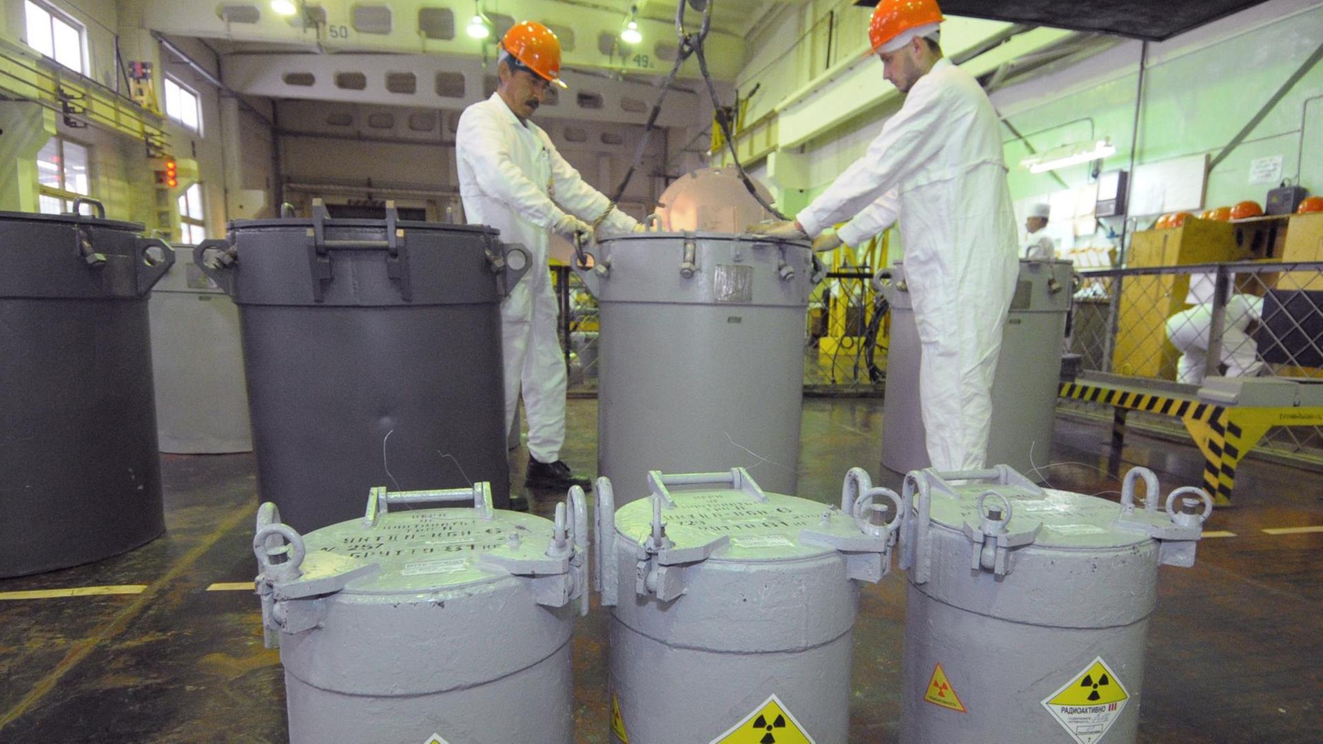 Mitarbeiter in der russischen kerntechnischen Anlage Majak neben Behältnissen, die laut Kennzeichnung radioaktives Material enthalten Mitarbeiter in der russischen kerntechnischen Anlage Majak neben Behältnissen, die laut Kennzeichnung radioaktives Material enthalten