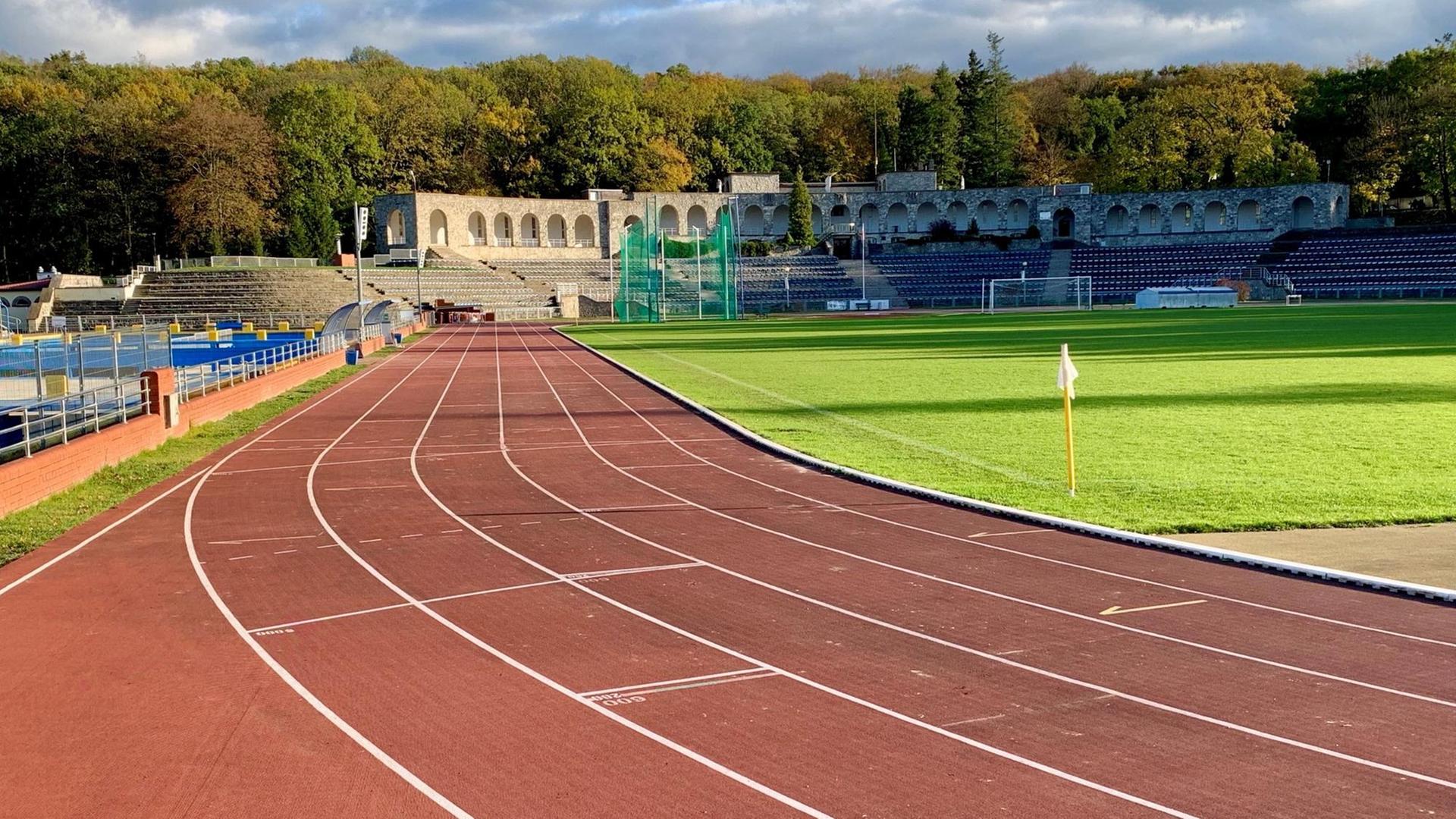 Laufbahn mit Tribünen vor Fußballfeld Laufbahn mit Tribünen vor Fußballfeld