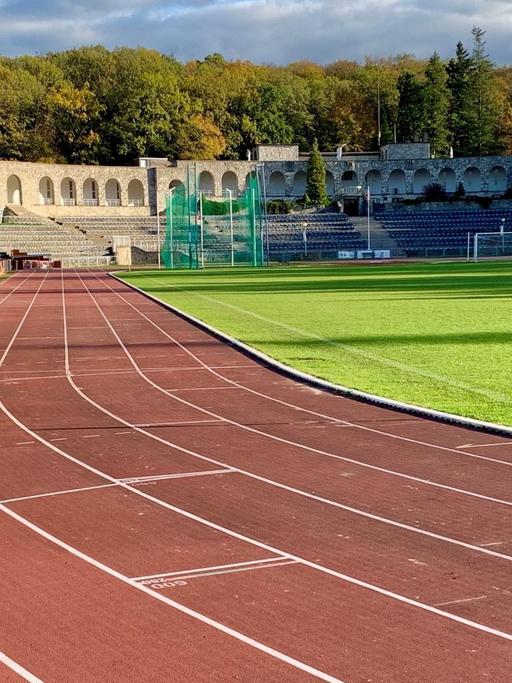 Laufbahn mit Tribünen vor Fußballfeld