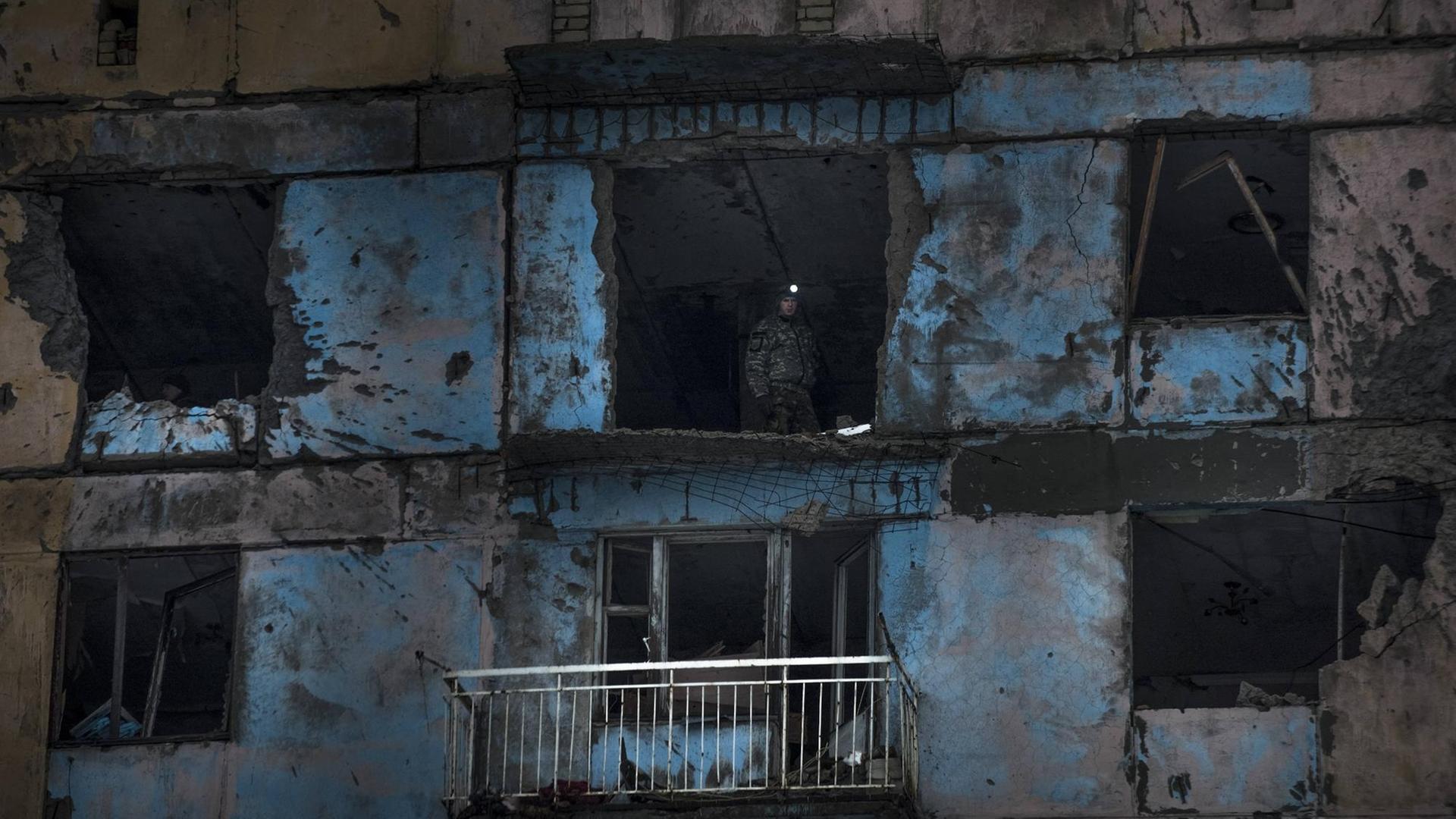 Ein Kämpfer des ukrainischen Rechten Sektors steht in einem beschädigten Gebäude in Awdijiwka. Ein Kämpfer des ukrainischen Rechten Sektors steht in einem beschädigten Gebäude in Awdijiwka.