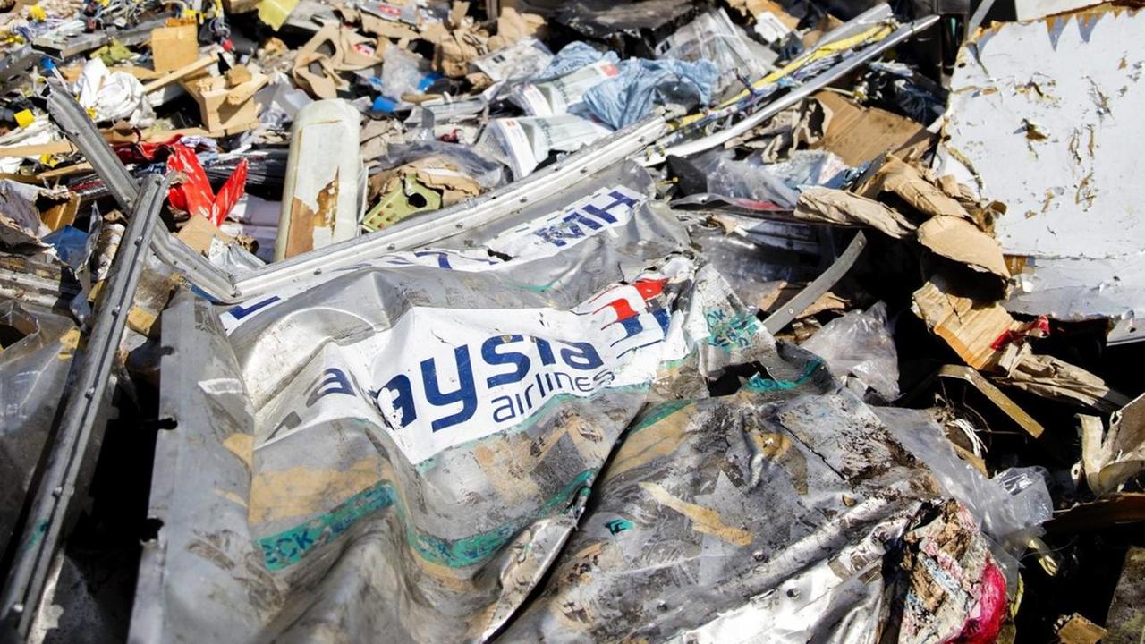 Trümmer des Flugzeugs Boeing 777 von Malaysia Airlines Flug MH17 liegen im Osten der Ukraine auf einem Feld.