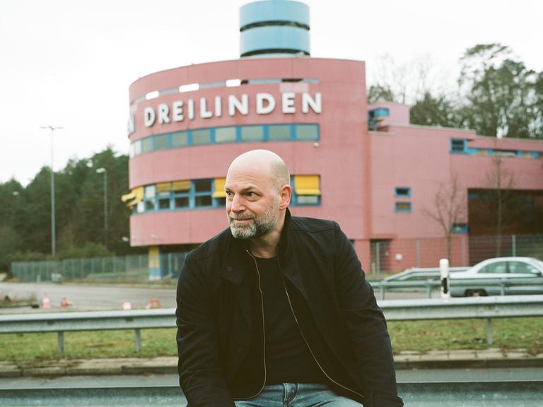 Florian Werner auf der Leitplanke vor einer Raststätte