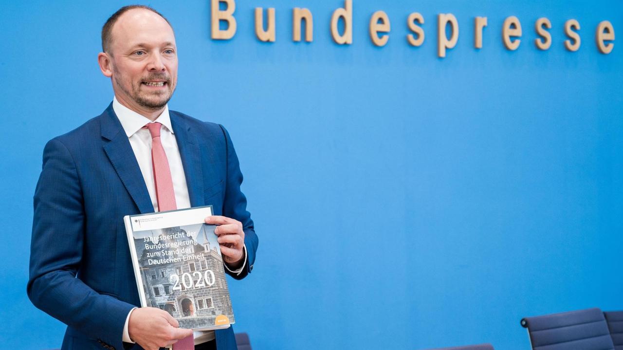 Berlin: Marco Wanderwitz (CDU), Ostbeauftragter der Bundesregierung, zeigt bei der Vorstellung den Jahresbericht zum Stand der Deutschen Einheit 2020.