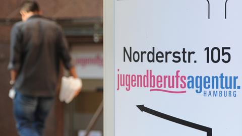 Ein Mann geht in Hamburg auf den Eingang der Jugendberufsagentur zu.