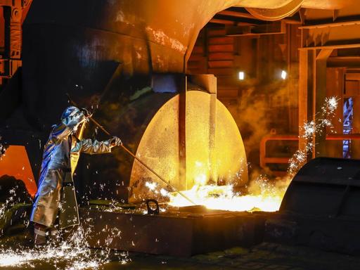 Stahlarbeiter im Schutzanzug entnimmt eine 1.500 Grad heiße Roheisenprobe beim Abstich am Hochofen im Stahlwerk Thyssen Krupp Steel in Duisburg, 15.04. 2019