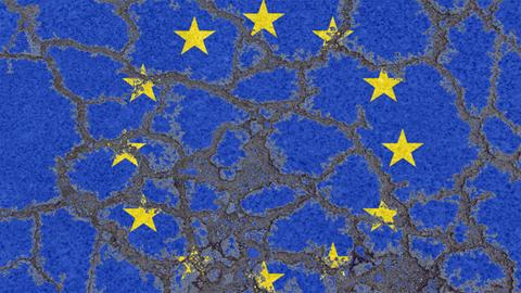 Die Flagge der Europäischen Union auf erodierendem Asphalt Eine auf Asphalt gemalte EU-Flagge hat Risse bekommen.