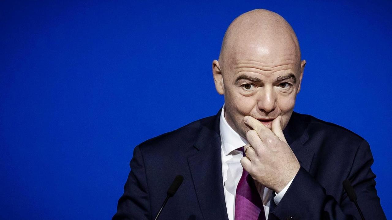 Portrait von FIFA-Präsidenten Gianni Infantino, der sich nachdenklich an den Mund fasst Portrait von FIFA-Präsidenten Gianni Infantino, der sich nachdenklich an den Mund fasst