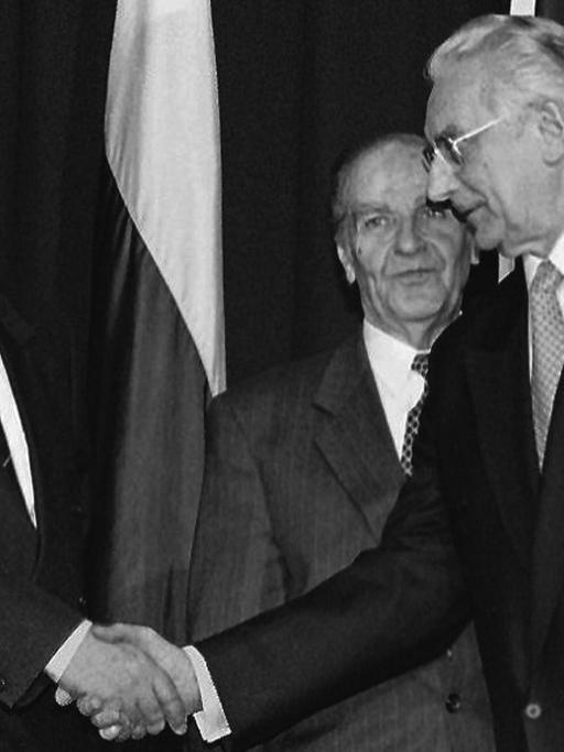 Die einstigen Feinde schütteln sich die Hände: Alija Izetbegovic (Bosnien, Mitte) sieht dabei Franjo Tudjman (Kroatien, rechts) und Slobodan Milosevic (Serbien, links) nach der Unterzeichnung des Friedensvertrages für Bosnien-Herzegowina am Dienstag (21.11.95) in Dayton (US-Bundeststaat Ohio) zu. |