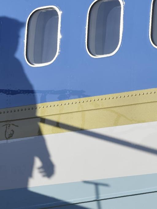 Donald Trump wirft seinen Schatten an die Bordwand der Air Force One.