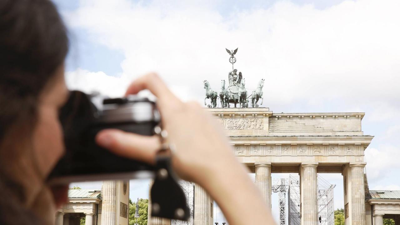 Eine Frau fotografiert das Brandenburger Tor in Berlin Eine Frau fotografiert das Brandenburger Tor in Berlin