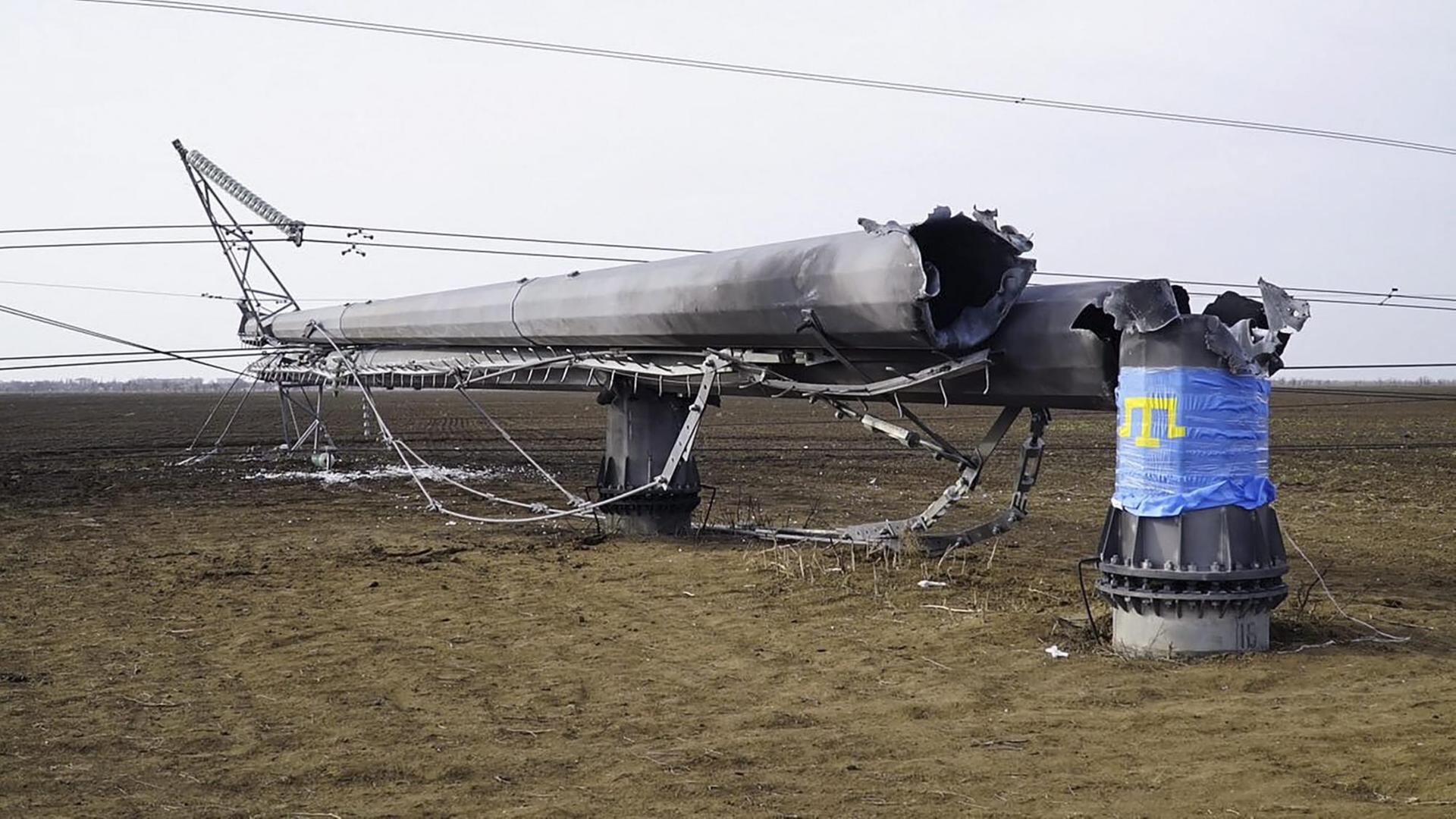 Der gesprengte Mast liegt auf einem Feld. Die Flagge ist blau. Der gesprengte Mast liegt auf einem Feld. Die Flagge ist blau.