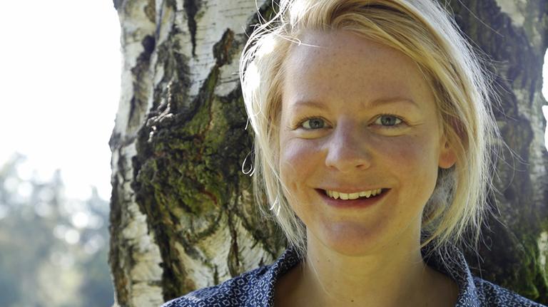 Anna Leuschner lehnt an einer Birke und lächelt in die Kamera Anna Leuschner lehnt an einer Birke und lächelt in die Kamera