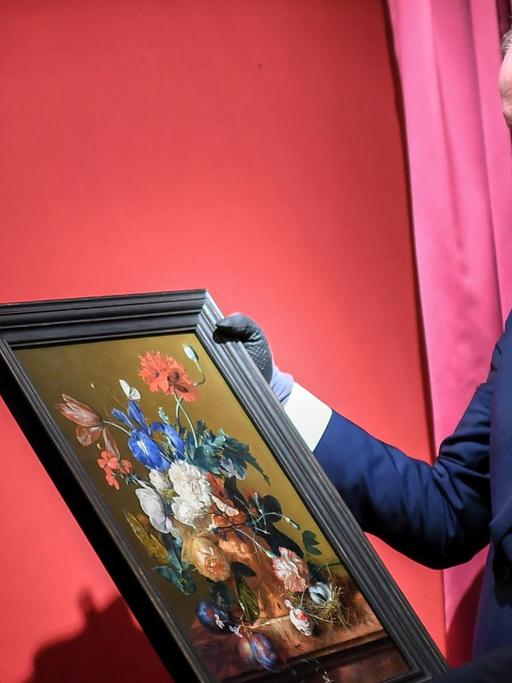 Eike Dieter Schmidt, Direktor der Uffizien, hängt ein Gemälde an seinen Platz.