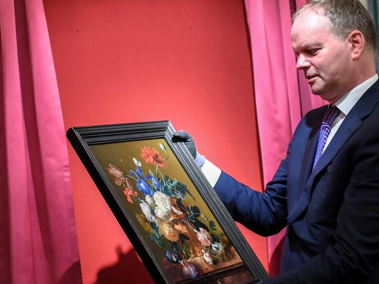 Eike Dieter Schmidt, Direktor der Uffizien, hängt ein Gemälde an seinen Platz.