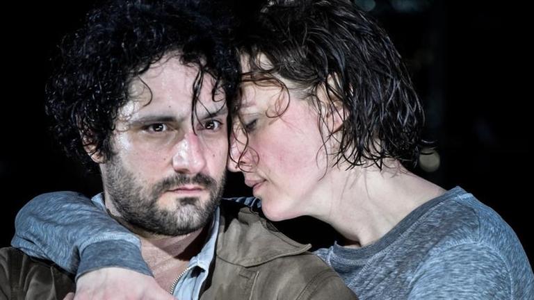 Die Schauspielerin Maren Eggert umarmt den Schauspieler Edgar Eckert von der Seite und stützt ihr Kinn auf seine Schulter. Beide Darsteller sind naß, er blickt ernst, sie hat die Augen geschlossen Die Schauspielerin Maren Eggert umarmt den Schauspieler Edgar Eckert von der Seite und stützt ihr Kinn auf seine Schulter. Beide Darsteller sind naß, er blickt ernst, sie hat die Augen geschlossen