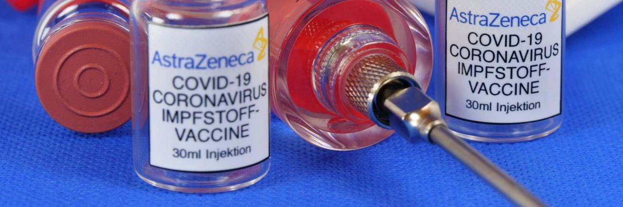 Zwei Phiolen mit dem Coronaserum-Impfstoff von AstraZeneca. Dazwischen liegt eine Spritze. Zwei Phiolen mit dem Coronaserum-Impfstoff von AstraZeneca. Dazwischen liegt eine Spritze.