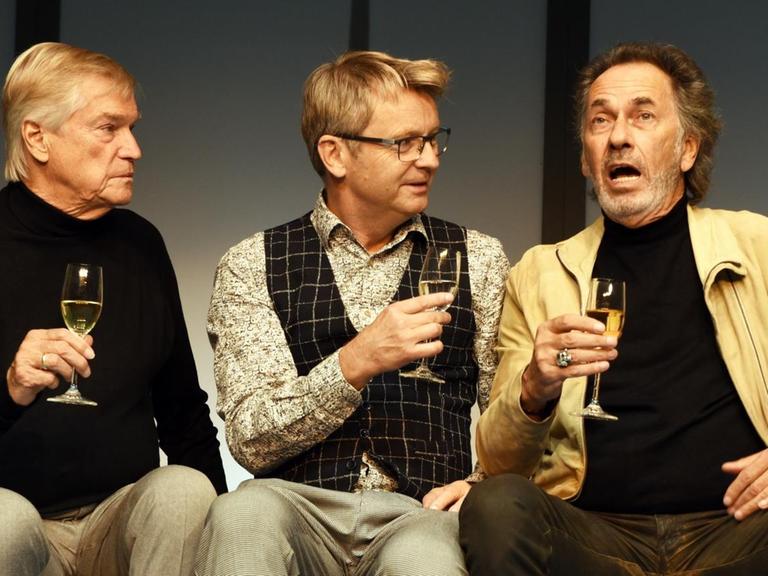 In der Komödie "Komplexe Väter", stoßen die Schauspieler (l-r) Jochen Busse, Rene Heinersdorff, Hugo Egon Balder mit einem Sekt an.