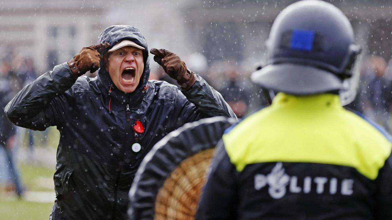Ein regierungskritischer Demonstrant steht bei einer Kundgebung am Museumsplatz einem Polizisten gegenüber.