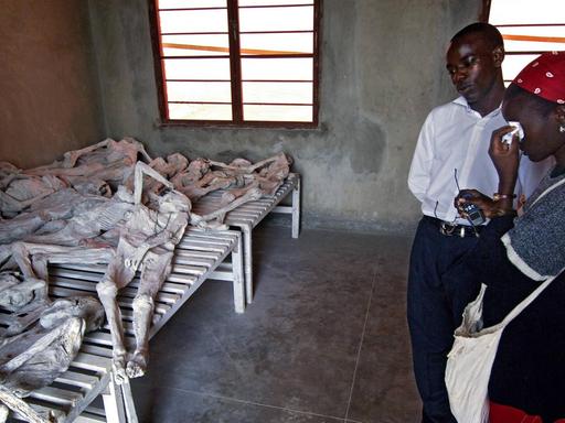 Eine Frau weint neben einem Mann in der Gedenkstätte Murambi in Ruanda am 24.05.2005 neben durch gelöschten Kalk mumifizierten Opfern des Genozids. Der Völkermord an den Tutsi in Ruanda schockierte 1994 die ganze Welt.