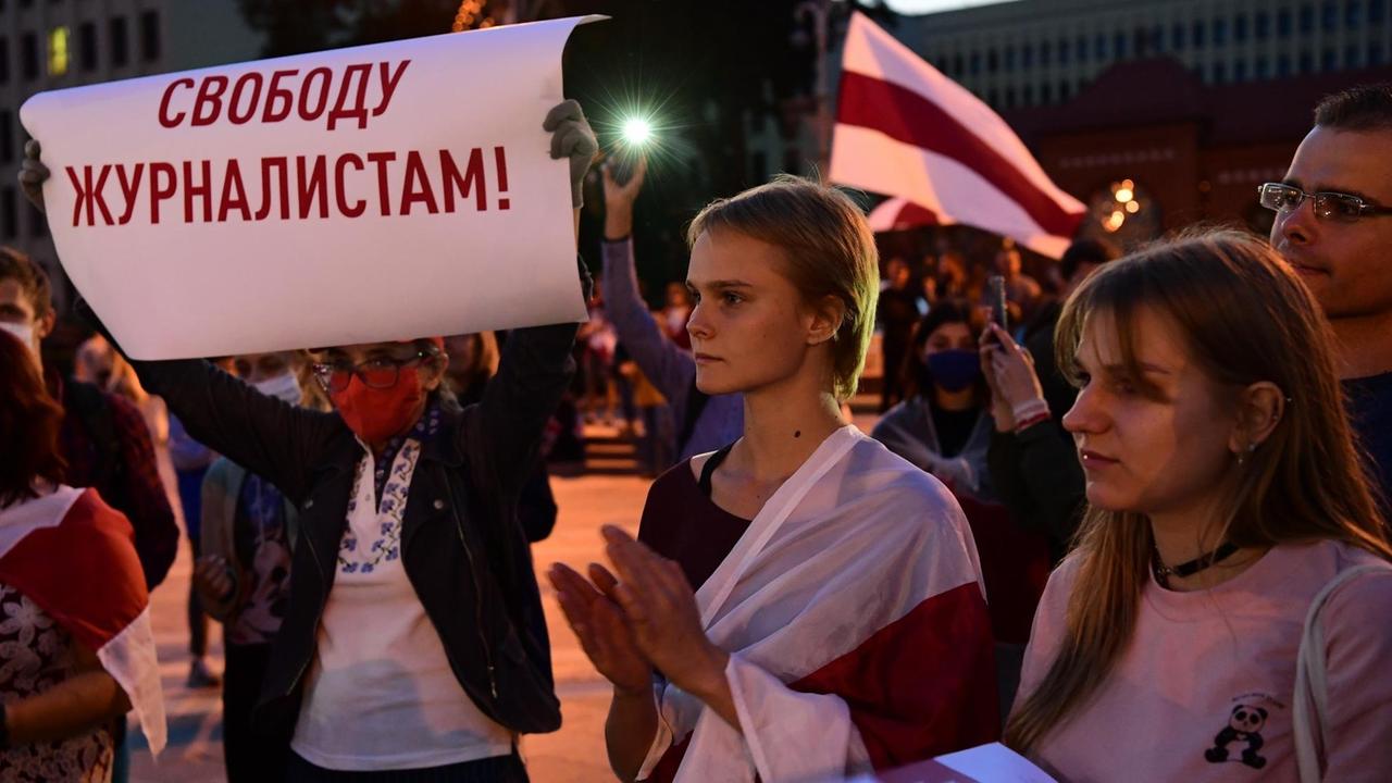 Mehrere Demonstrantinnen und Demonstranten, eine Frau hält ein Schilder in die Höhe, auf dem steht: "Gebt Journalisten Freiheit" Mehrere Demonstrantinnen und Demonstranten, eine Frau hält ein Schilder in die Höhe, auf dem steht: "Gebt Journalisten Freiheit"