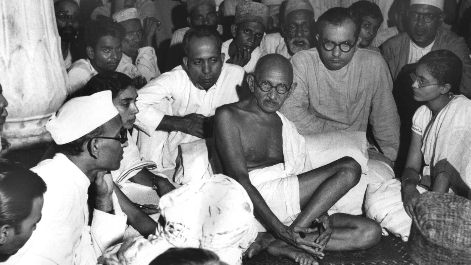 Gandhi sitzt in einer undatierten Aufnahme bei Muslimen in Neu-Delhi und versucht, die blutigen Auseinandersetzungen zwischen den Muslimen und den Hindus zu schlichten. Gandhi sitzt in einer undatierten Aufnahme bei Muslimen in Neu-Delhi und versucht, die blutigen Auseinandersetzungen zwischen den Muslimen und den Hindus zu schlichten.