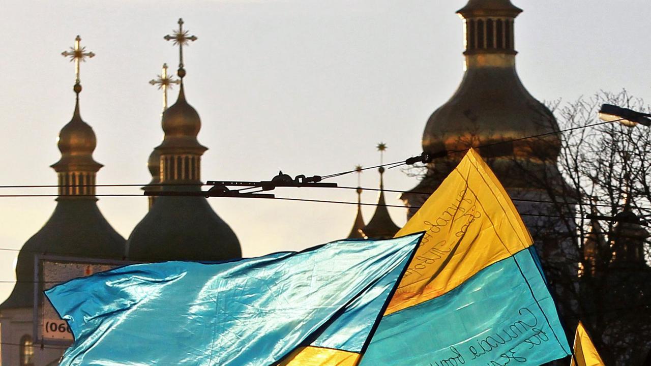 Menschen schwenken Ukraine-Fahnen auf dem Maidan in Kiew. Menschen schwenken Ukraine-Fahnen auf dem Maidan in Kiew.