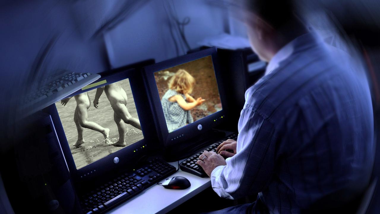 Ein Mann sitzt am Computer und sieht sich Bilder mit Kindern an. Ein Mann sitzt am Computer und sieht sich Bilder mit Kindern an.
