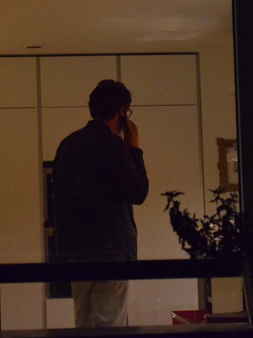 Ein Mann telefoniert in einem Wohnzimmer.