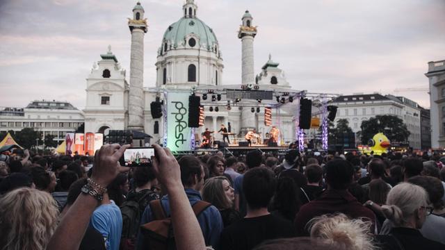 Besucher drängen sich vor der Bühne des popfests an der Wiener Karlskirche