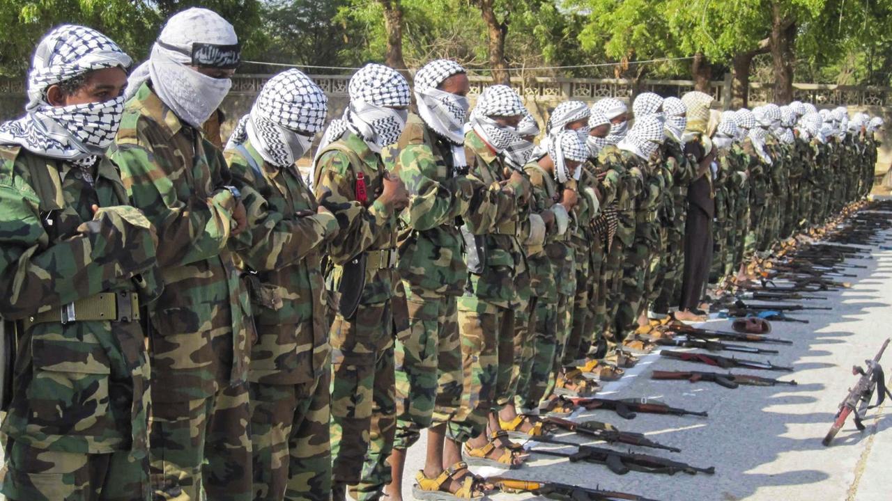 Vermummte Mitglieder der Al-Schabaab-Miliz in Somalia stehen in einer langen Reihe. Vermummte Mitglieder der Al-Schabaab-Miliz in Somalia stehen in einer langen Reihe.