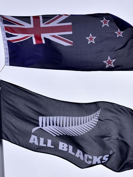 Die Flaggen von Neuseeland und die Flagge des All Blacks Rugby Teams wehen im Wind.